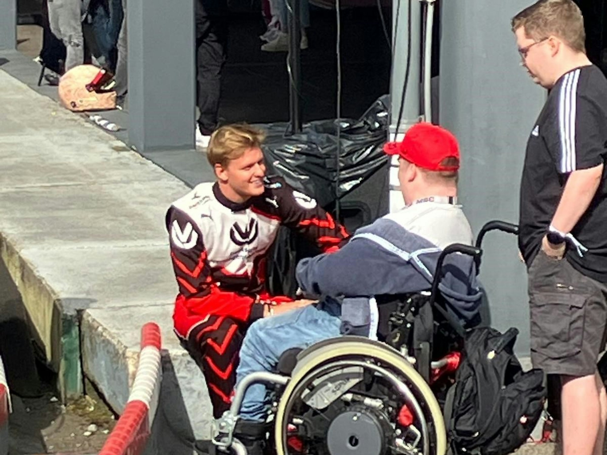 Mick Schumacher spricht mit Rollstuhlfahrer Tim (19) aus Birken Honigessen, der an einem Hirntumor erkrankt ist.
Foto: Heiko Debus