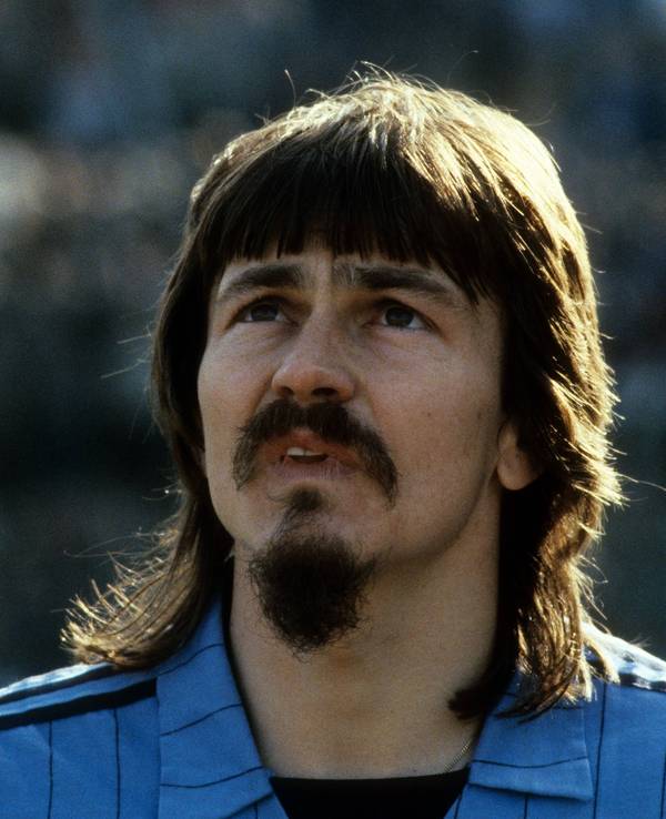 Ewald Lienen mit Vokuhila, Schnäuzer und Kinnbart.
