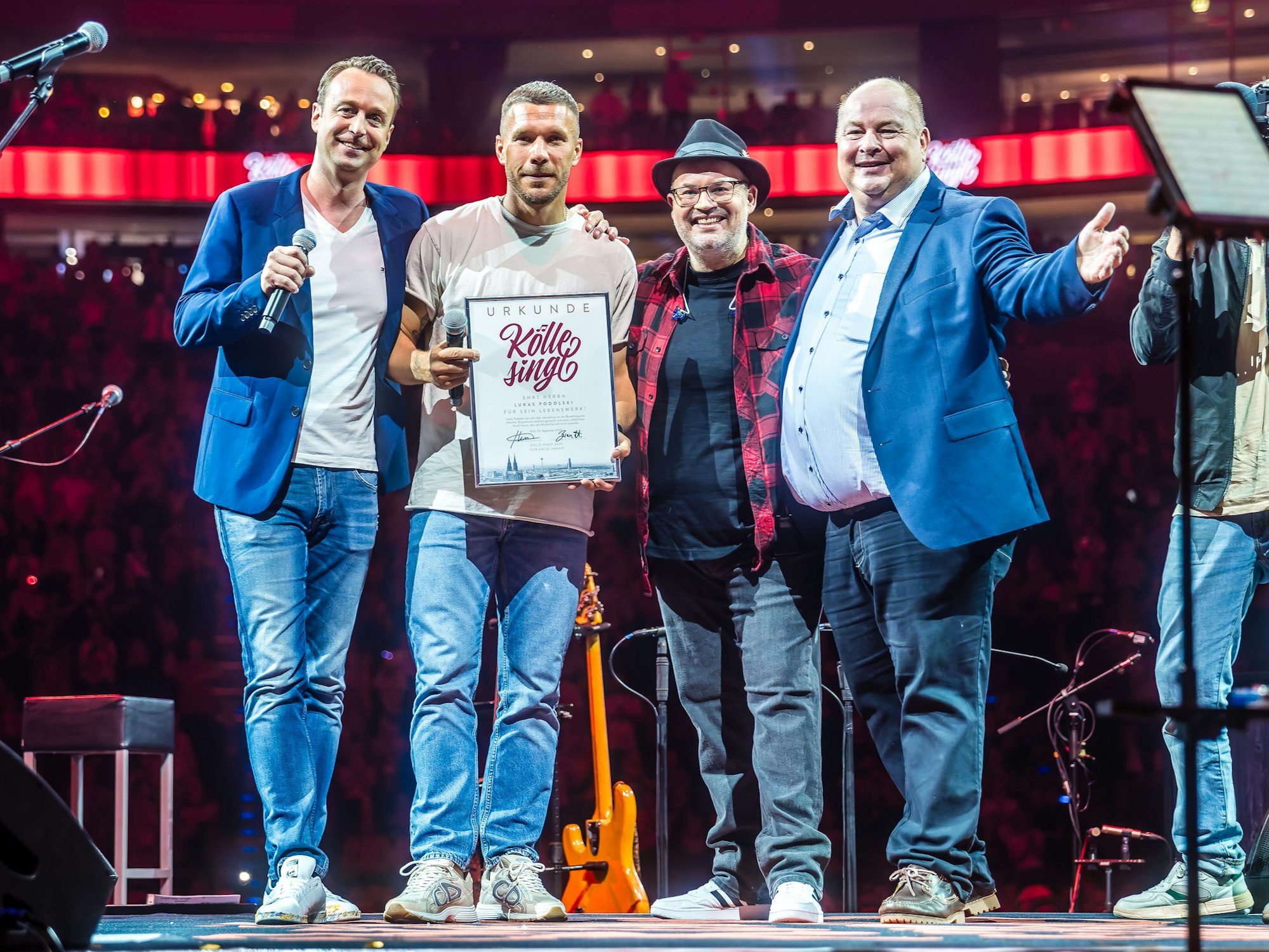 Lukas Podolski mit Urkunde bei Kölle singt.