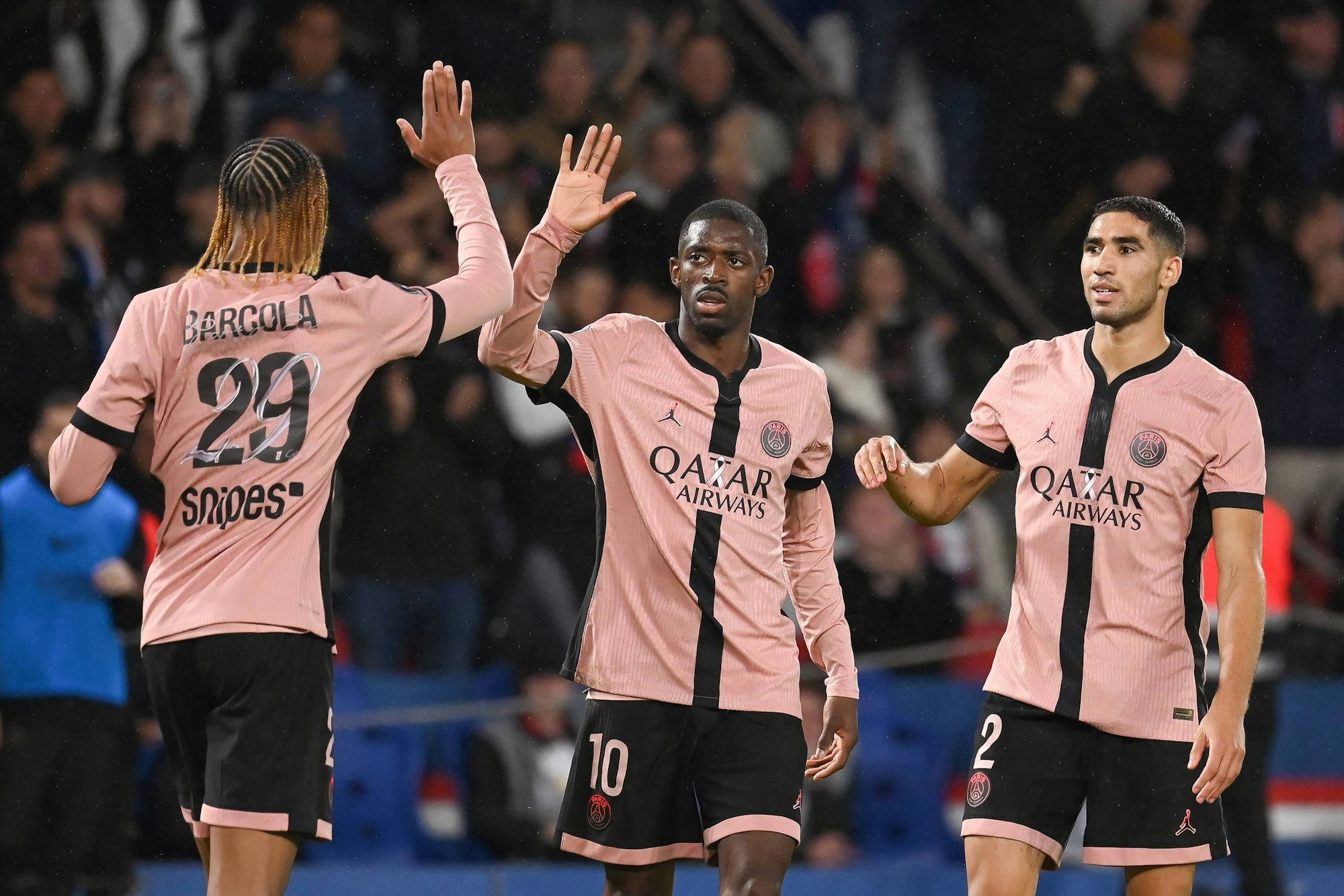 Bradley Barcola (l.), Ousmane Dembélé (M.) klatschen sich ab.