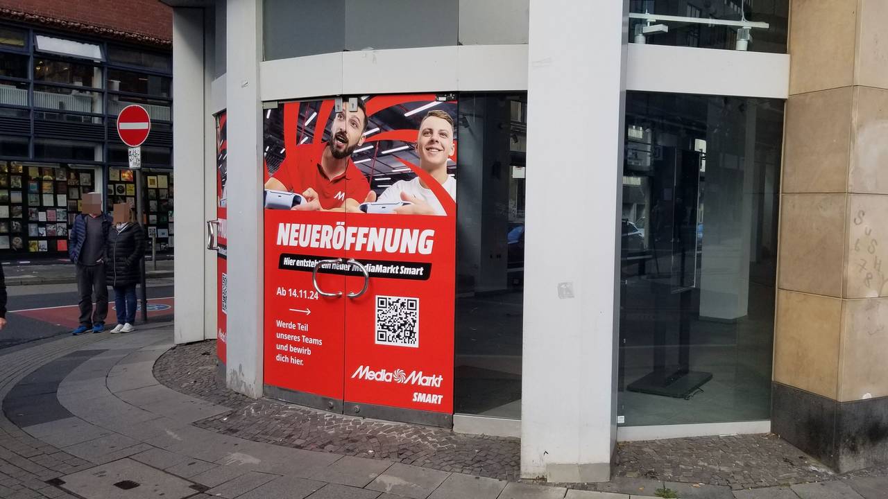 Ein Plakat weist auf die Eröffnung einer „Media Markt Smart“-Filiale hin.