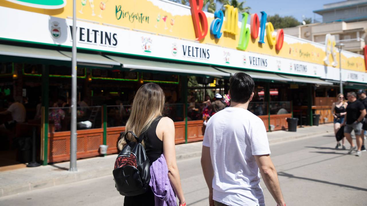 Menschen spazieren in der Schinkenstraße am Strand von Arenal auf Mallorca.