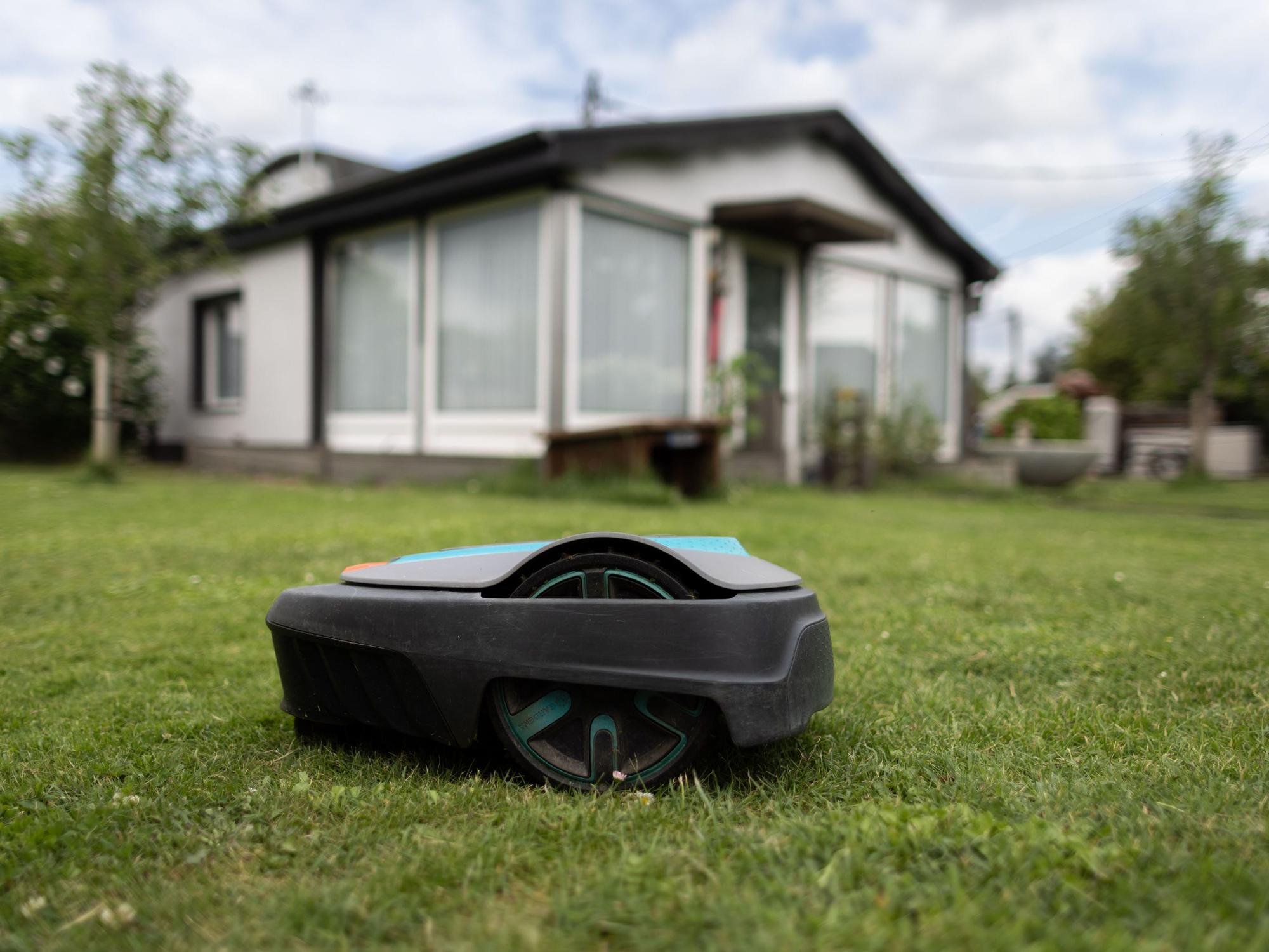 Ein Mähroboter steht auf einer Wiese.
