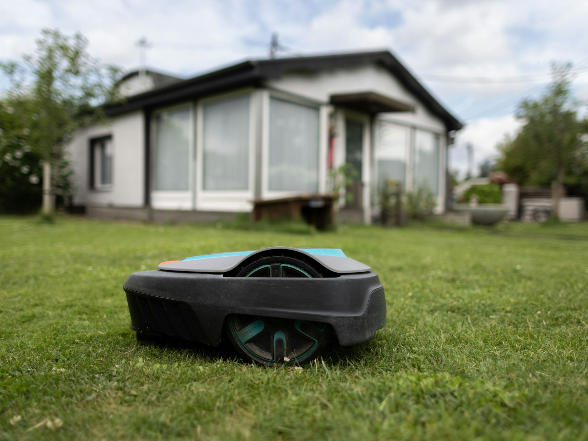 Ein Mähroboter steht auf einer Wiese.
