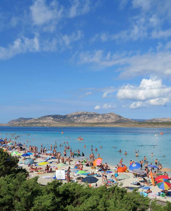 Badegäste am Strand auf der Mittelmeerinsel Sardinien.