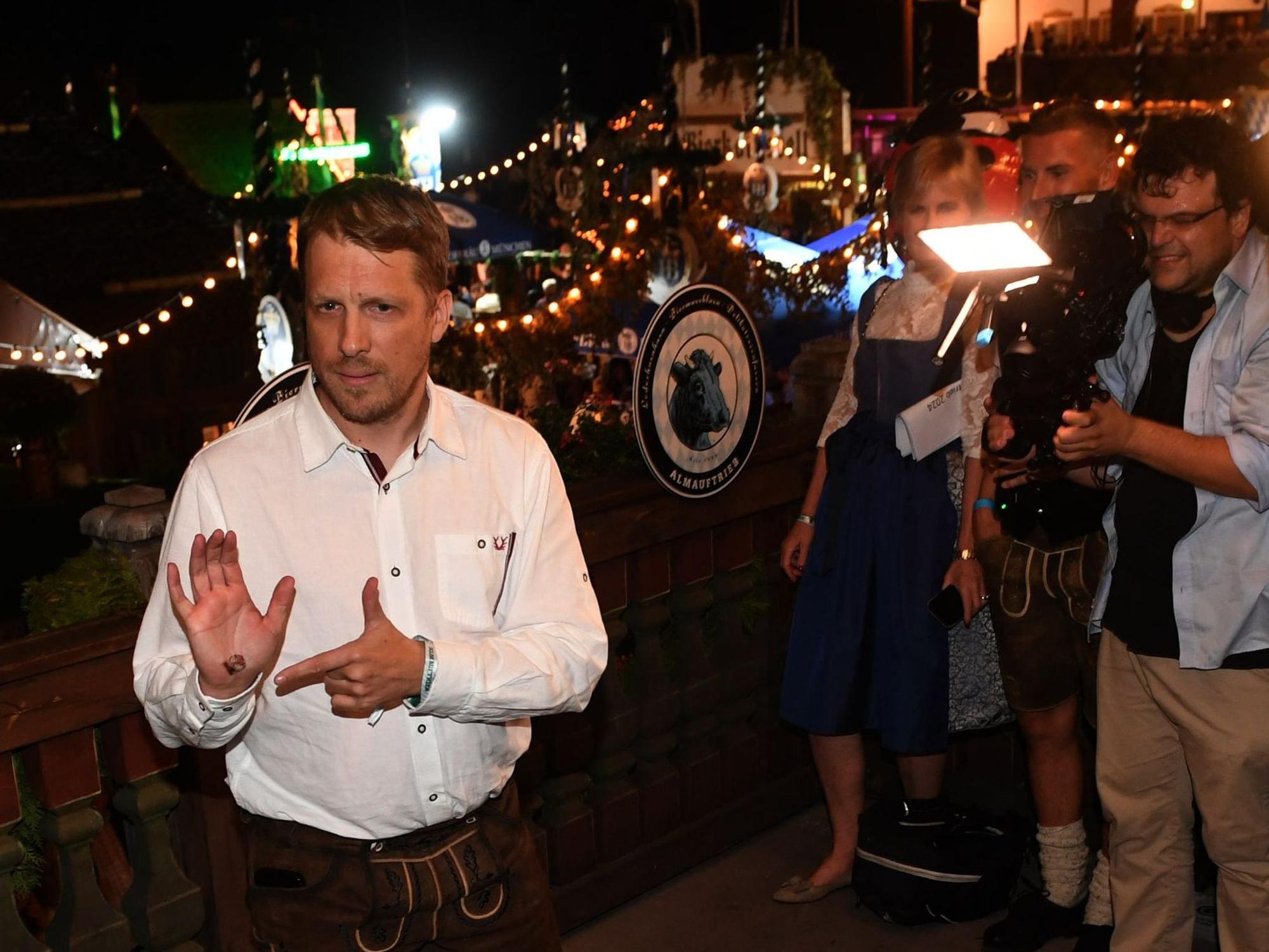 Der Comedian Oliver Pocher wird auf dem Balkon des Käferzelts beim Almauftrieb auf der Wiesn gefilmt und fotografiert.
