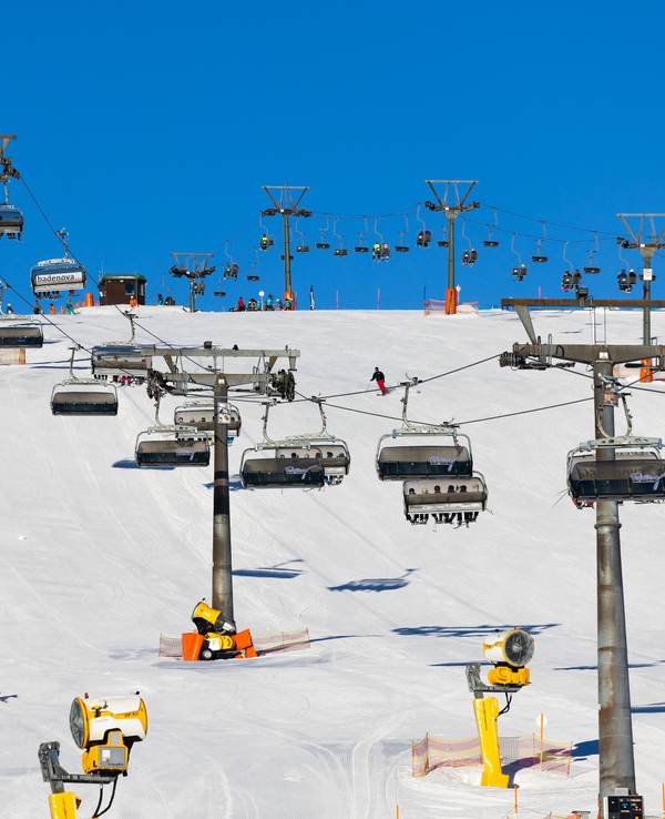 Wintersportler fahren unter den Kabinen der Feldbergbahn entlang.