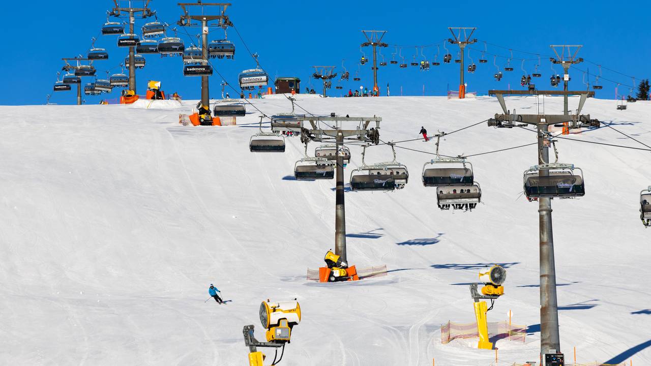 Wintersportler fahren unter den Kabinen der Feldbergbahn entlang.