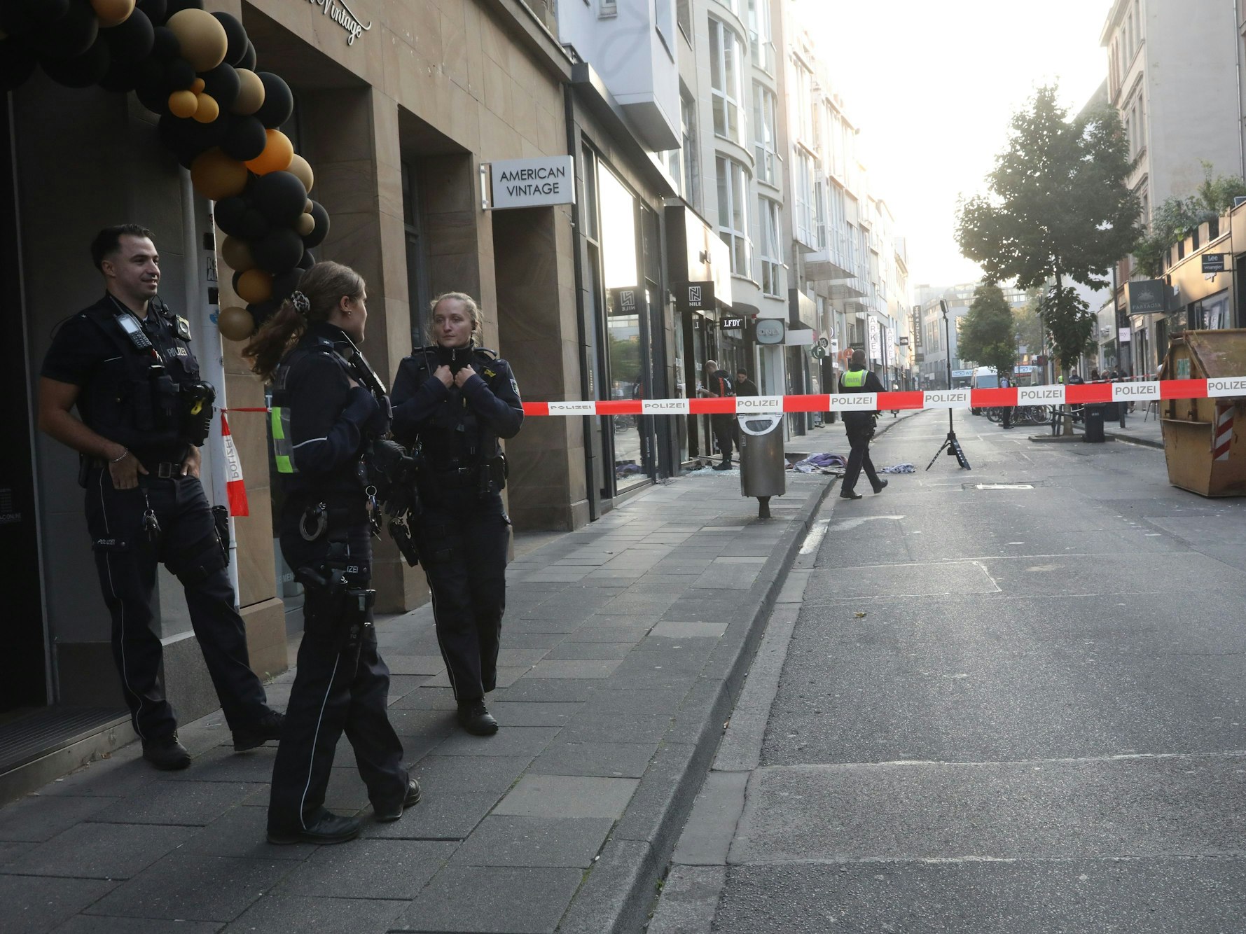 Polizisten stehen vor einem Geschäft, in dem eine Explosion stattfand.