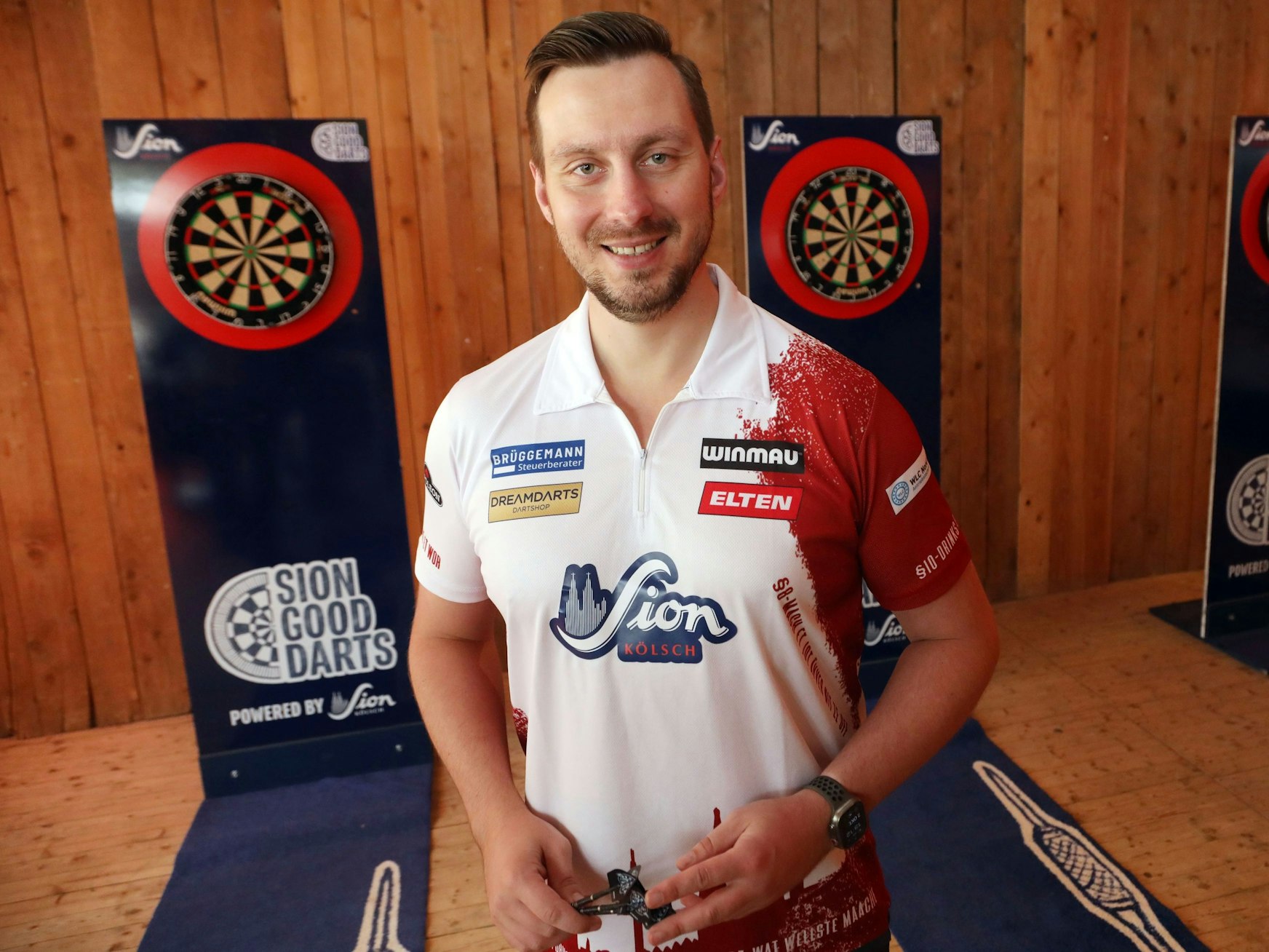 Darts-Spieler Florian Hempel steht vor den Scheiben.