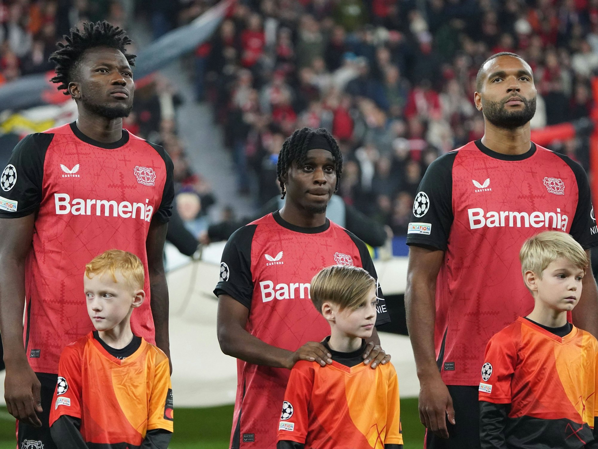 Edmond Tapsoba, Jeremie Frimpong und Jonathan Tah stehen nebeneinander.