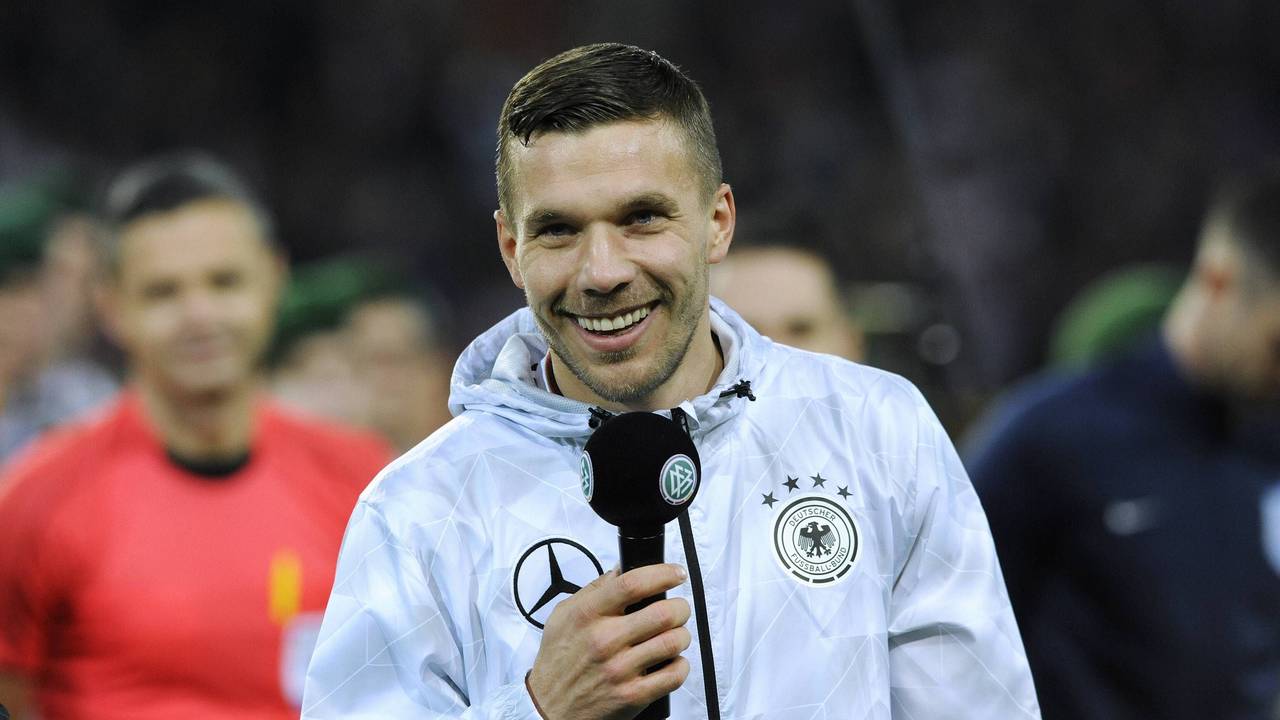 Lukas Podolski lacht mit Mikro in der Hand bei seinem DFB-Abschiedsspiel.