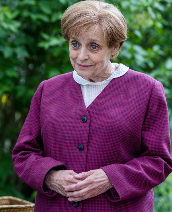 Miss Merkel (Katharina Thalbach) löst den Mordfall, während ihre geladenen Gäste ihr aufmerksam zuhören.