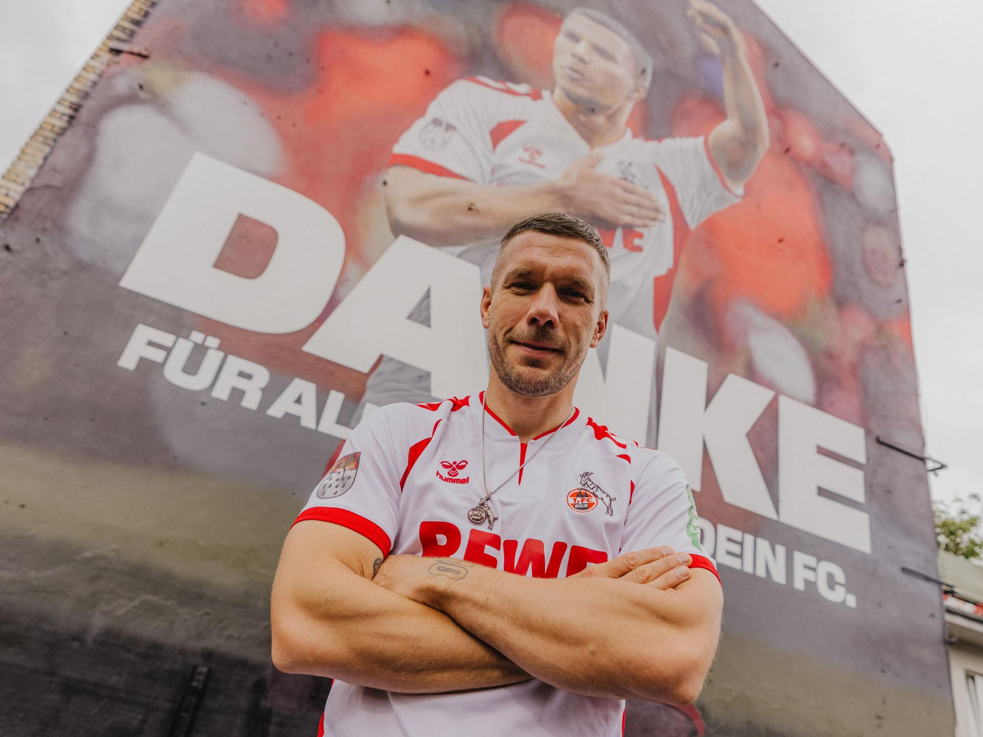 Lukas Podolski vor dem Wandgemälde in Ehrenfeld.