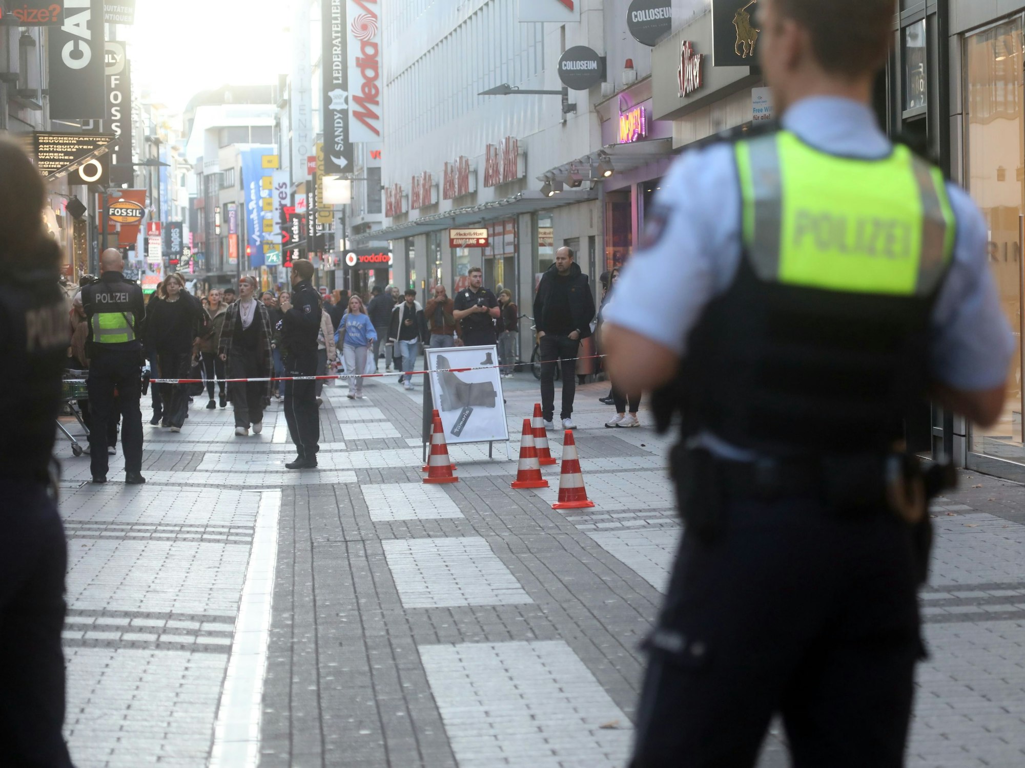 Die Polizei hat die Fußgängerzone abgesperrt, vor dem Flatterband stehen zwei Einsatzkräfte.