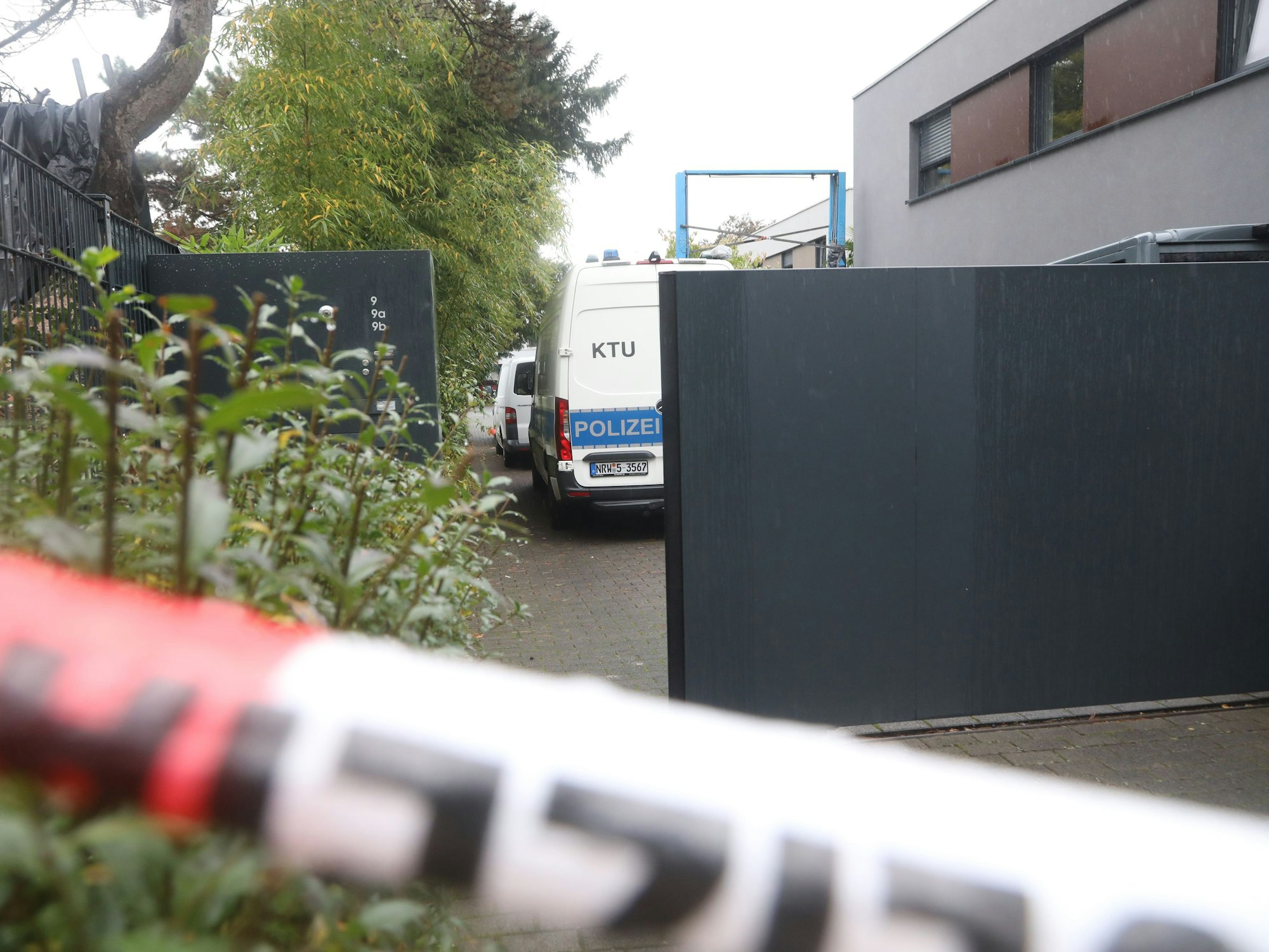 Polizei-Auto steht in einem abgesperrten Bereich vor der Villa des Toten in Köln.