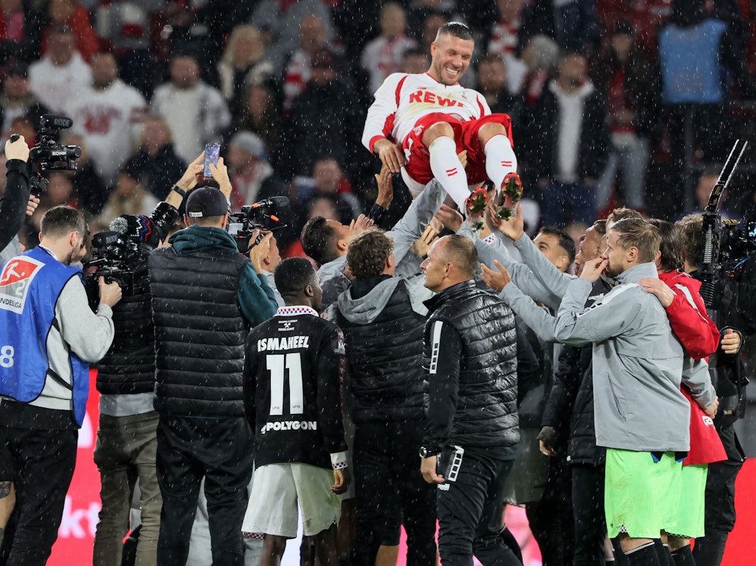 Lukas Podolski wird von seinen Mitspielern in die Luft geworfen.