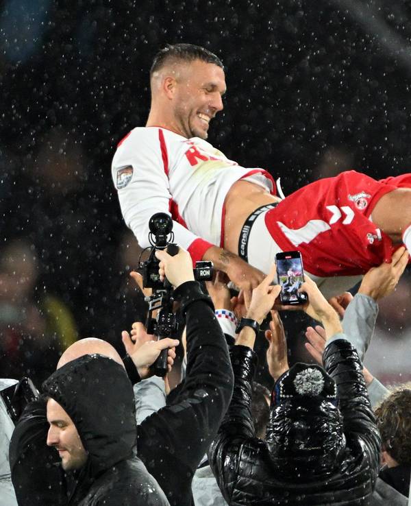 Mitspieler werfen Lukas Podolski in die Höhe.