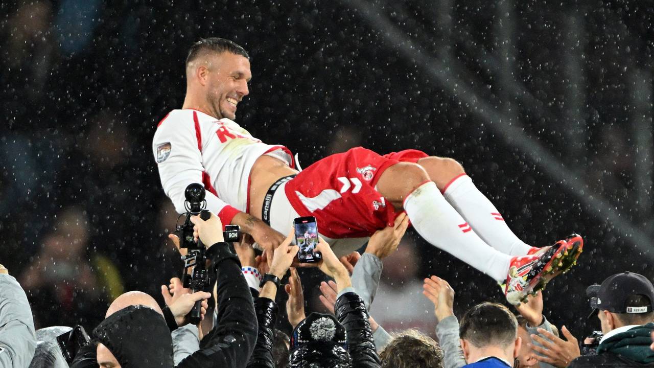 Mitspieler werfen Lukas Podolski in die Höhe.