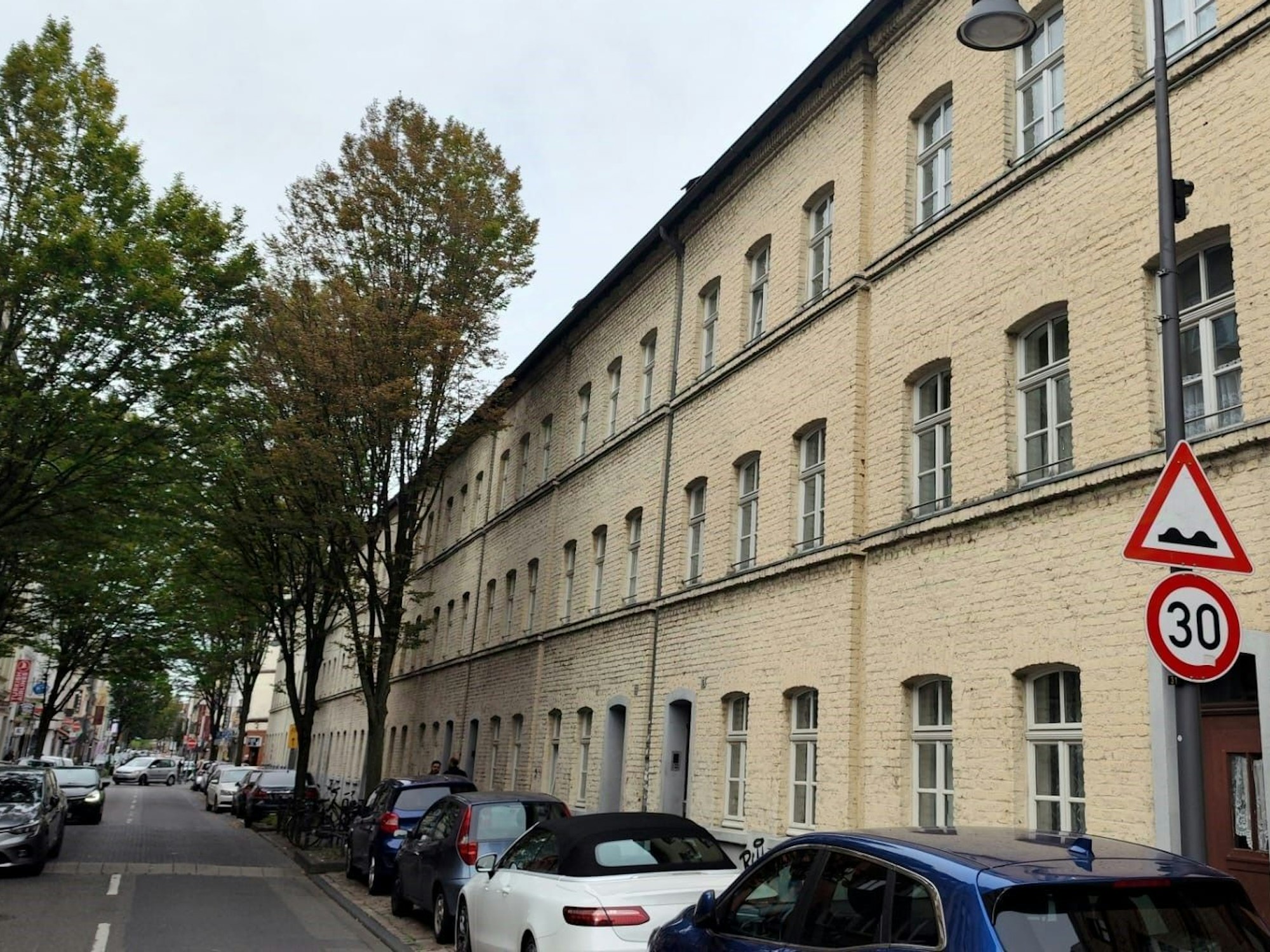 Vor ein Hauskomplex parken Autos.