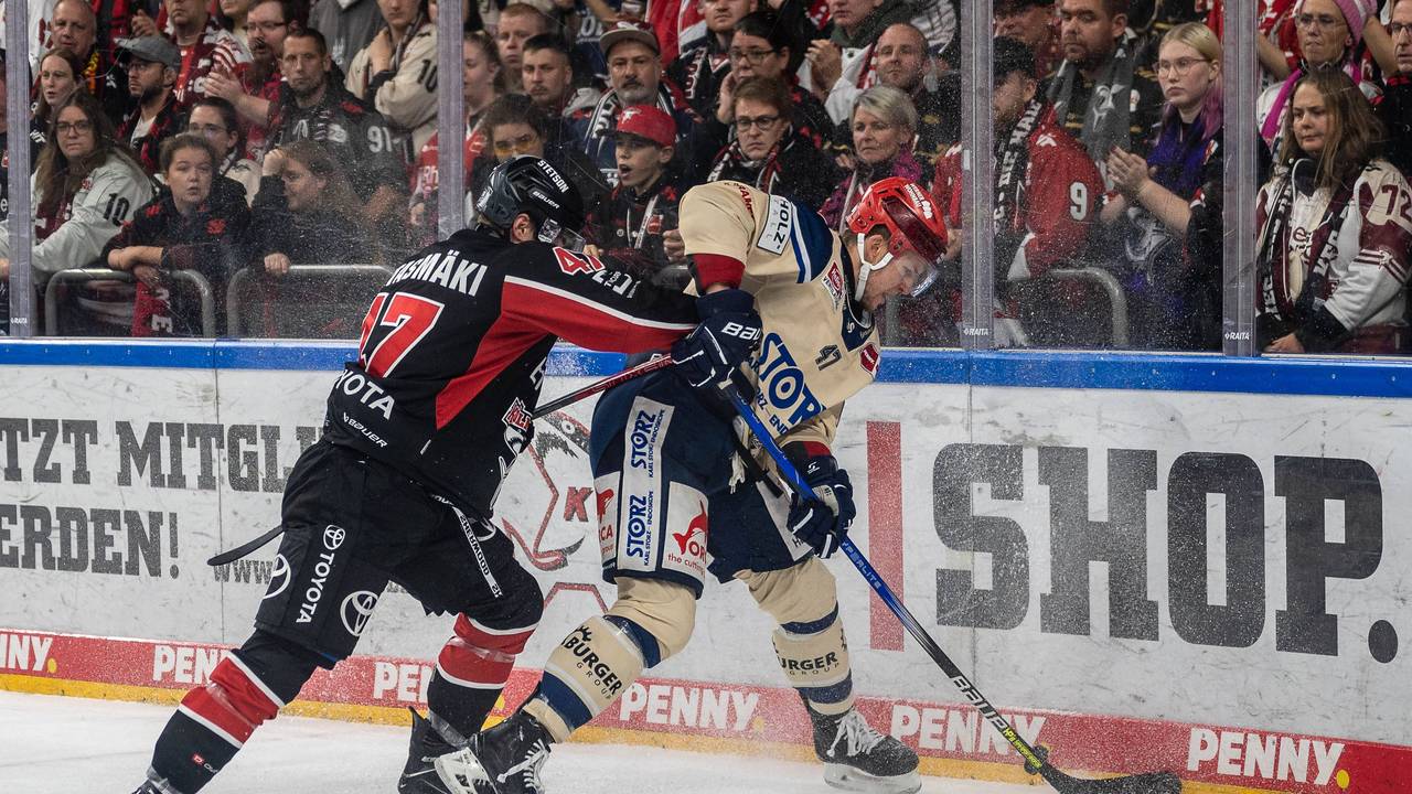 Matti Vittasmäki von den Kölner Haien im Duell um den Puck mit Alexander Karachun.