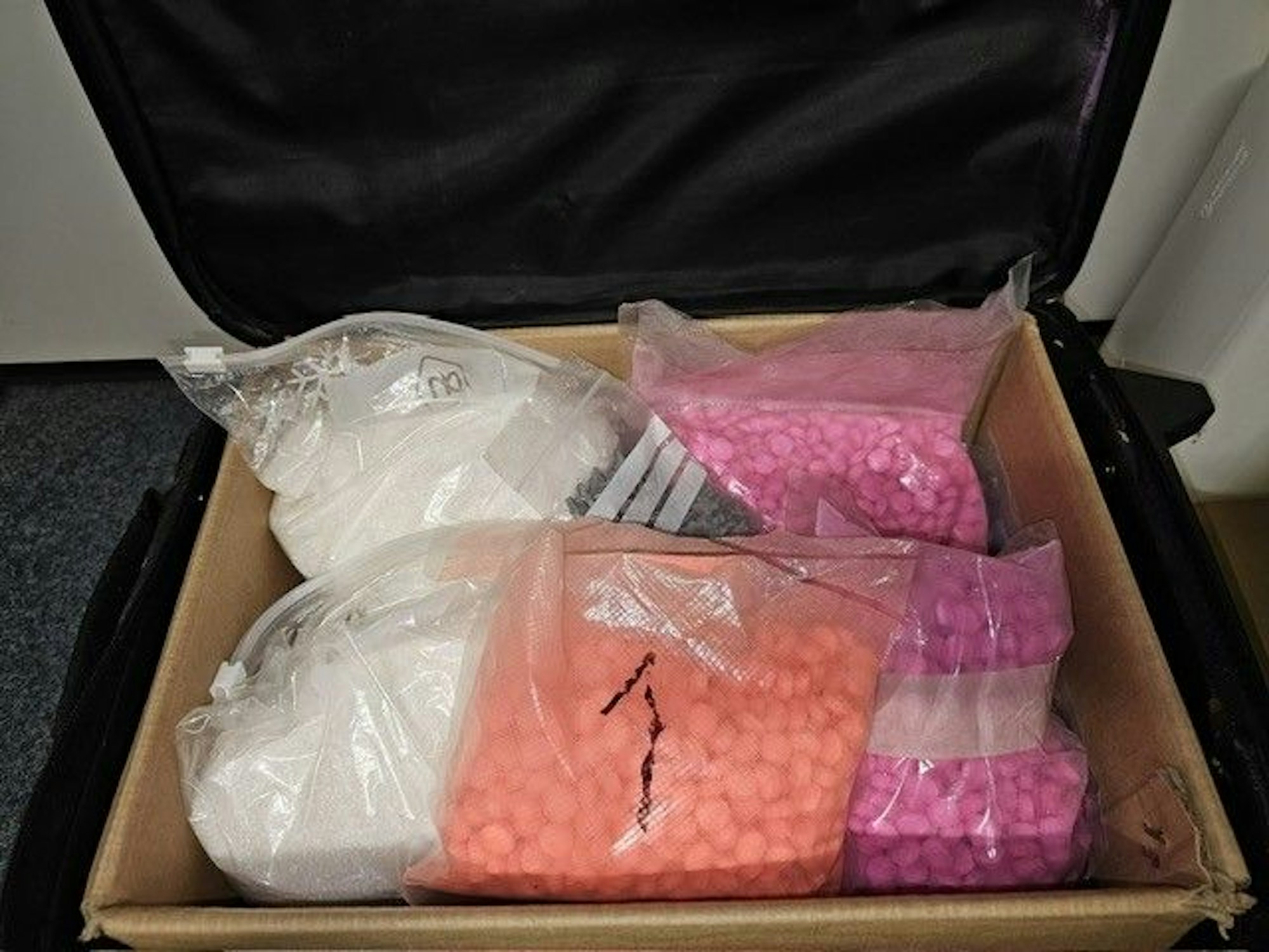 Abgepackte Drogen liegen in Plastiktüten in einem Karton.