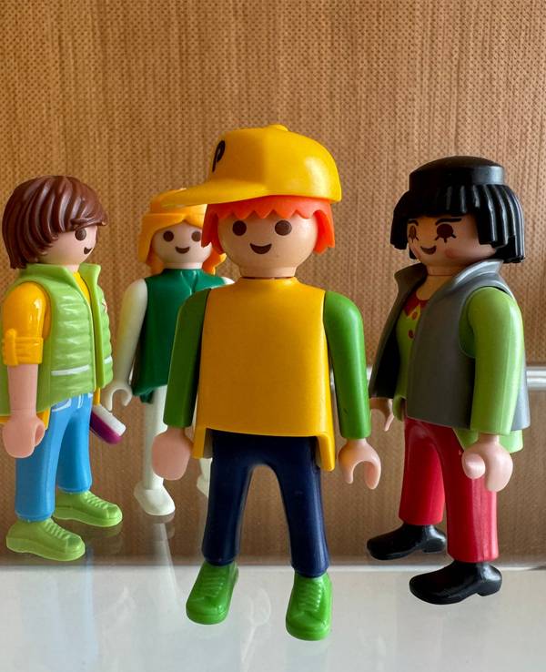 Männliche und weibliche Spielzeugfiguren stehen in einer Gruppe zusammen und sollen die Beziehungen zwischen Menschen symbolisieren.