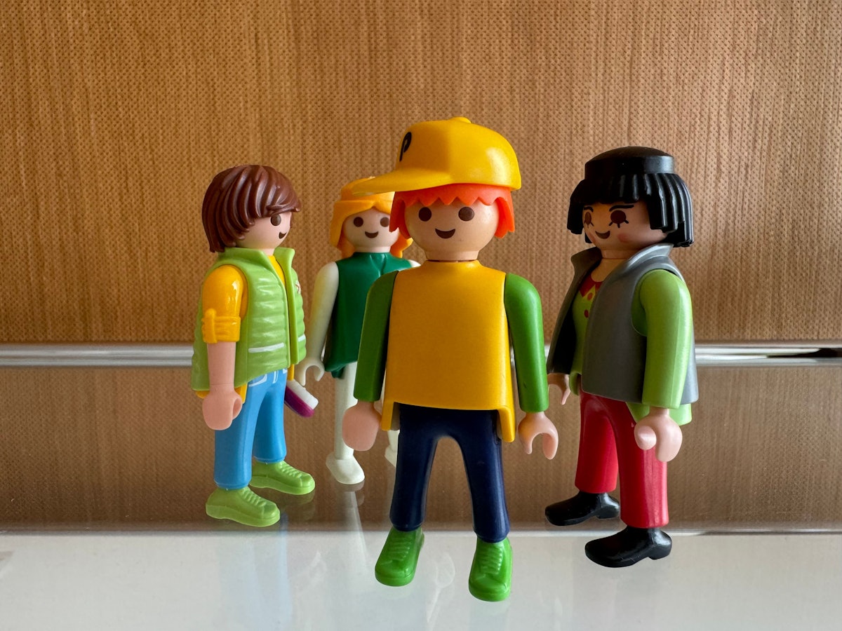 Männliche und weibliche Spielzeugfiguren stehen in einer Gruppe zusammen und sollen die Beziehungen zwischen Menschen symbolisieren.