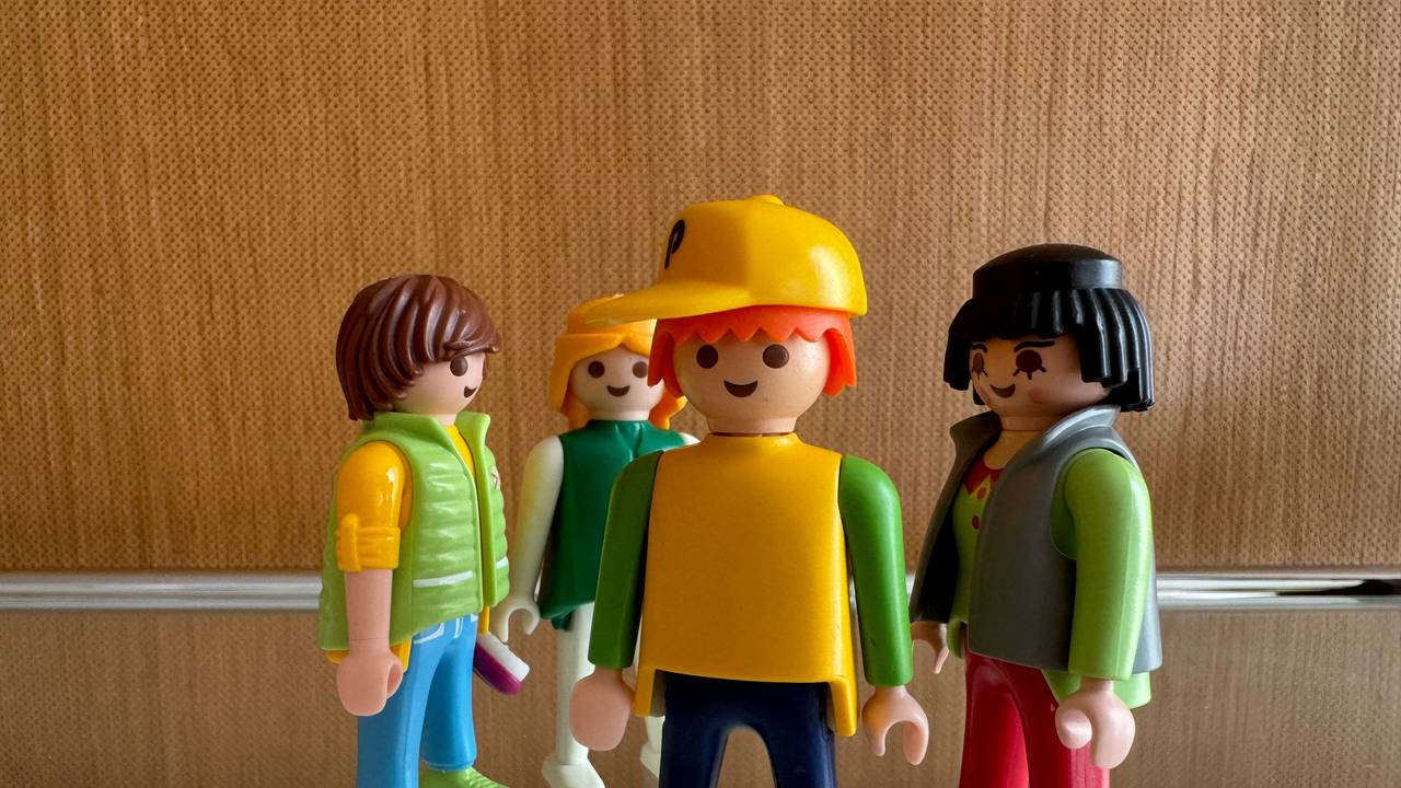 Männliche und weibliche Spielzeugfiguren stehen in einer Gruppe zusammen und sollen die Beziehungen zwischen Menschen symbolisieren.