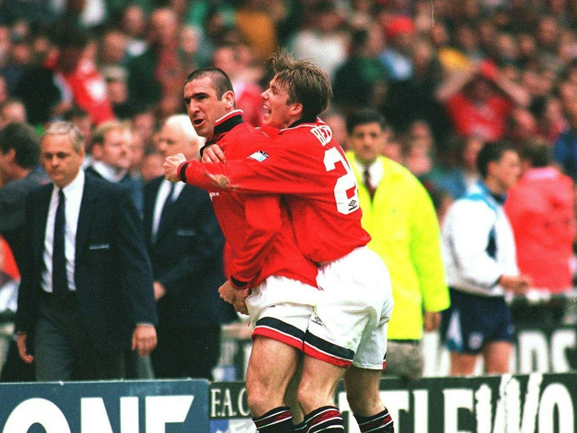 Eric Cantona jubelt über ein Tor mit David Beckham.
