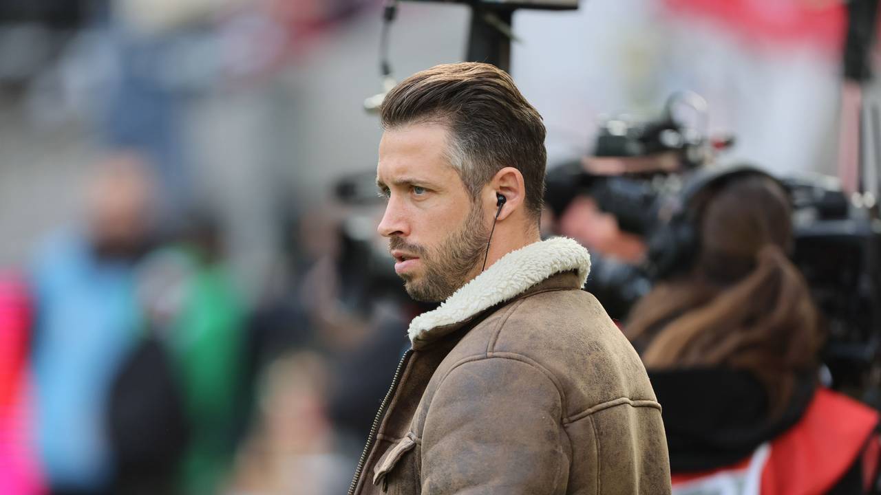 Mark Uth vor einem Interview mit Kopfhörer im Ohr.