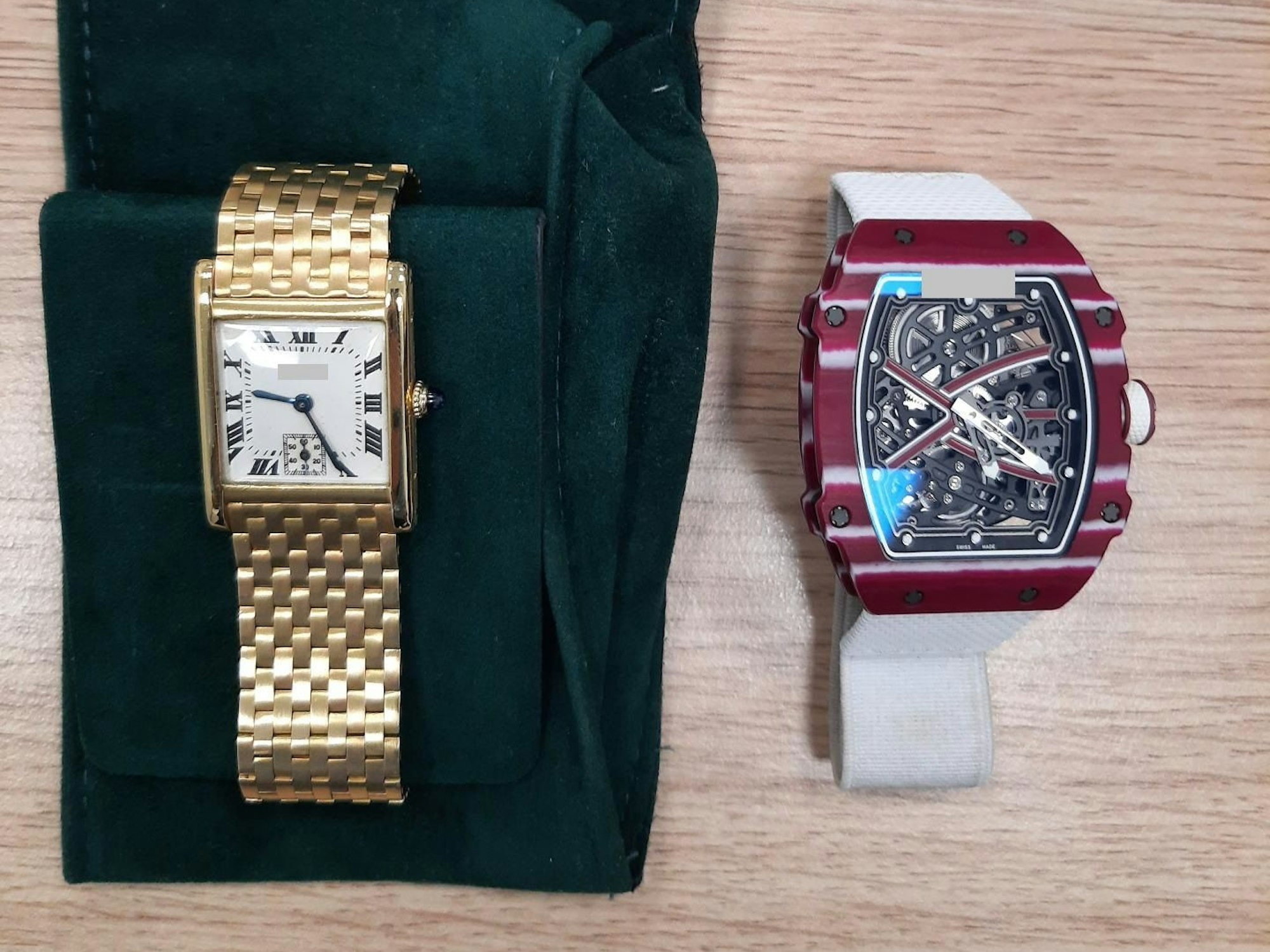 Eine elegante Armbanduhr liegt auf einem Samtstoff, daneben eine Uhr mit außergewöhnlichem Design, unter den Zeigern ist das Uhrwerk zu sehen.