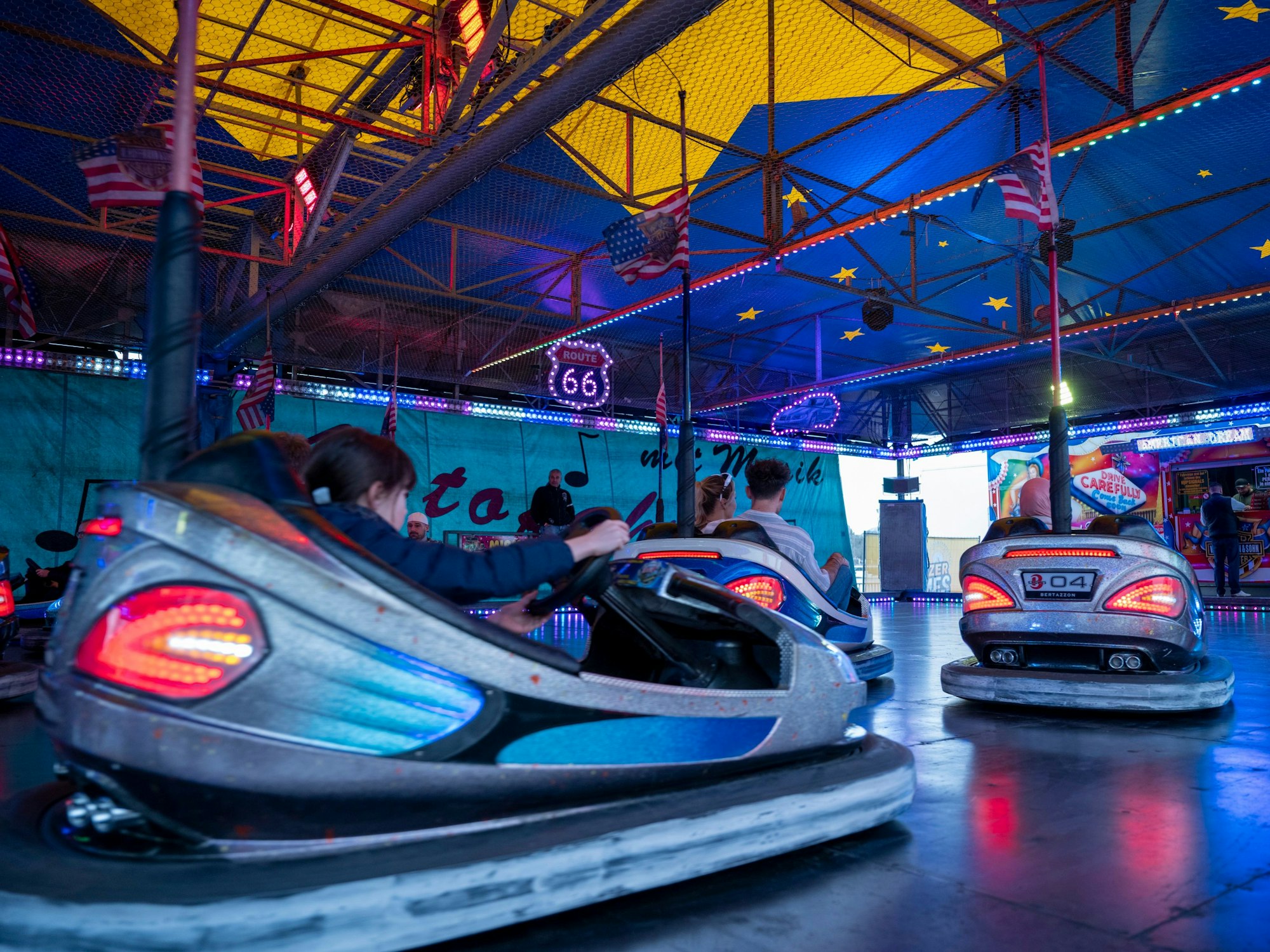 Menschen fahren mit Autoscooter-Fahrzeugen auf der Deutzer Kirmes.