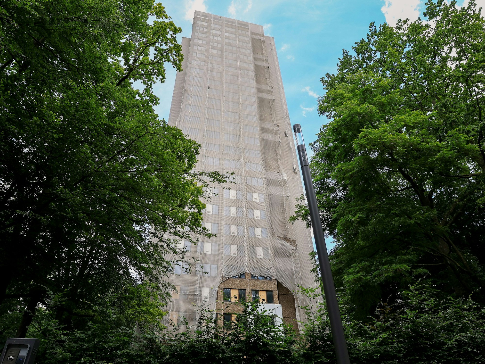 Der Wohnturm an der Deutschen Sporthochschule Köln ist in ein Netz gehüllt und wird weiter umgebaut.