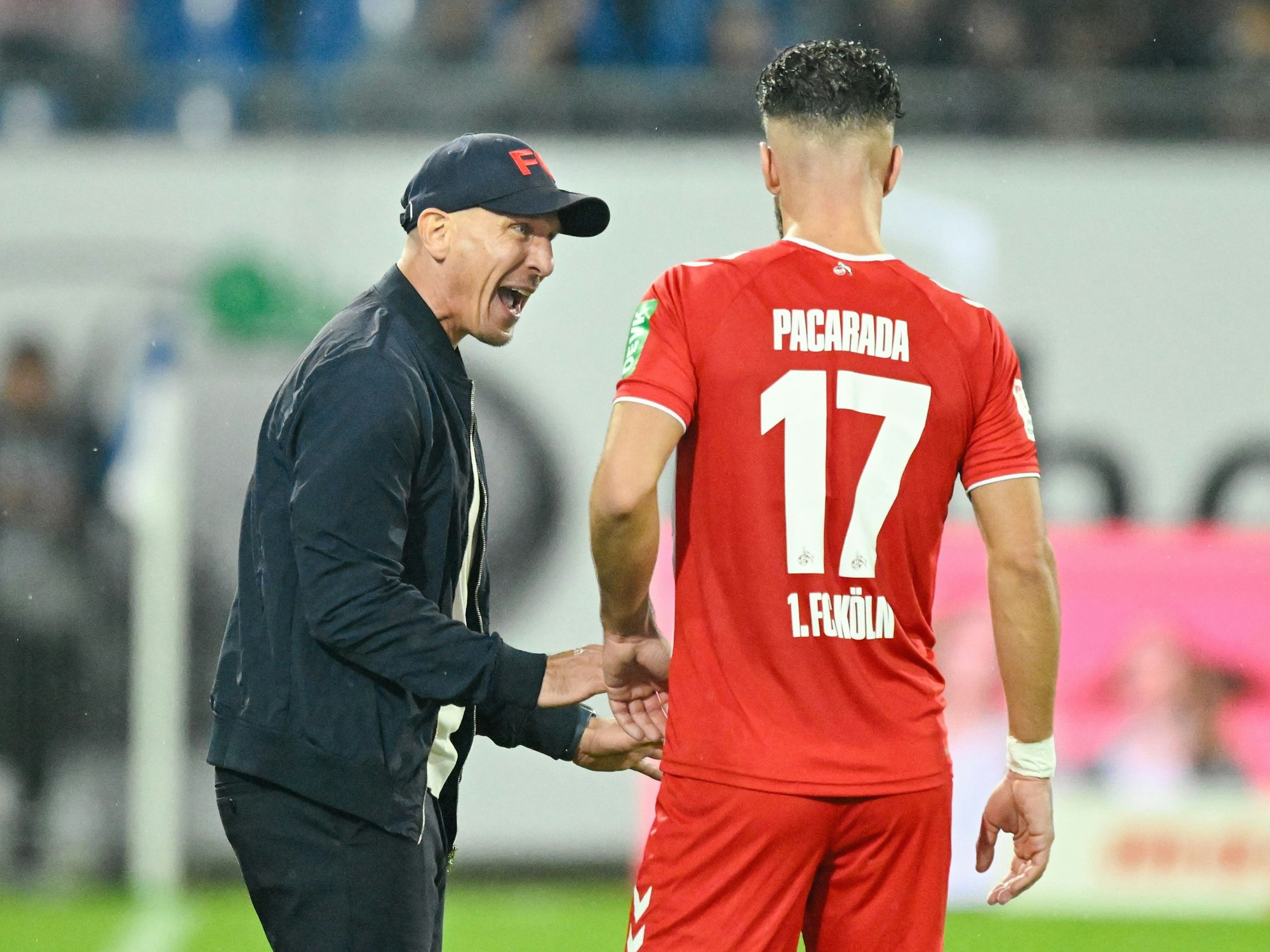Kölns Trainer Gerhard Struber (l) spricht mit Kölns Leart Paqarada in Darmstadt.