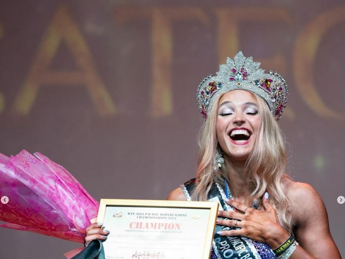 Lia Liebing steht auf der Bühne und hält ihre Urkunde in der Hand.