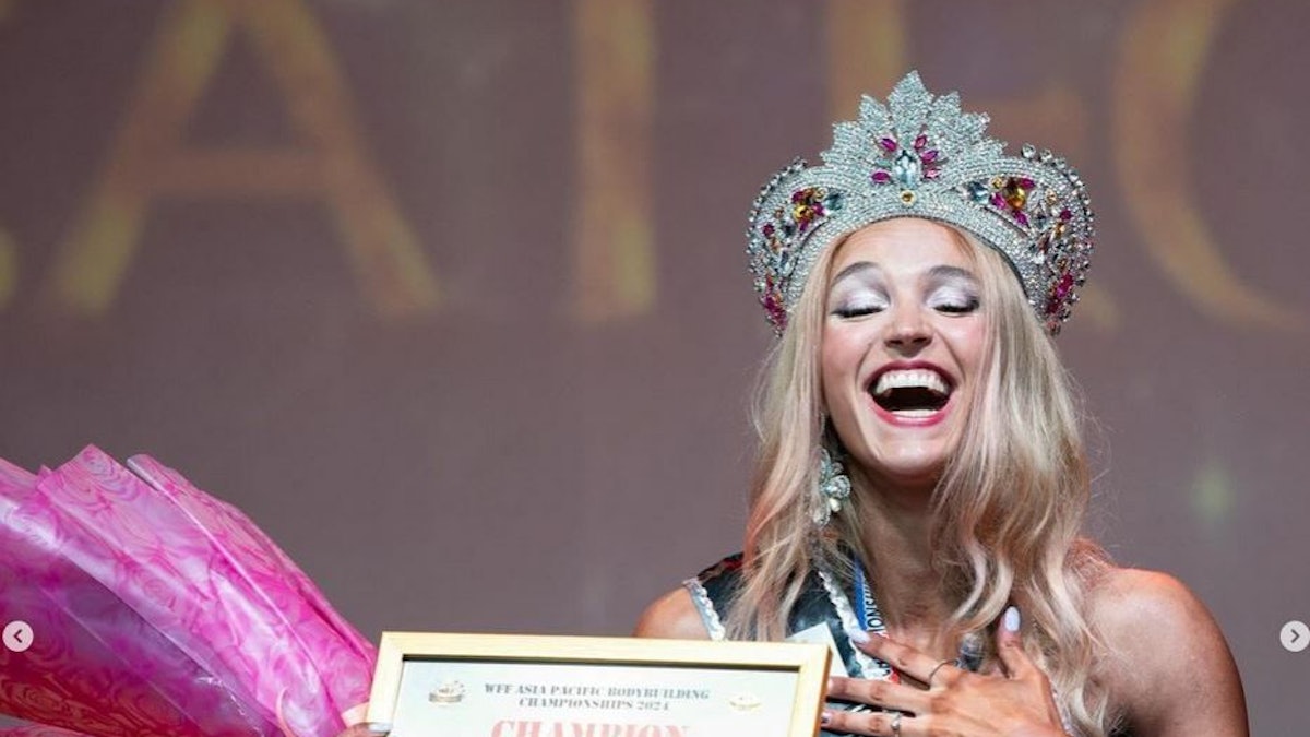 Lia Liebing steht auf der Bühne und hält ihre Urkunde in der Hand.