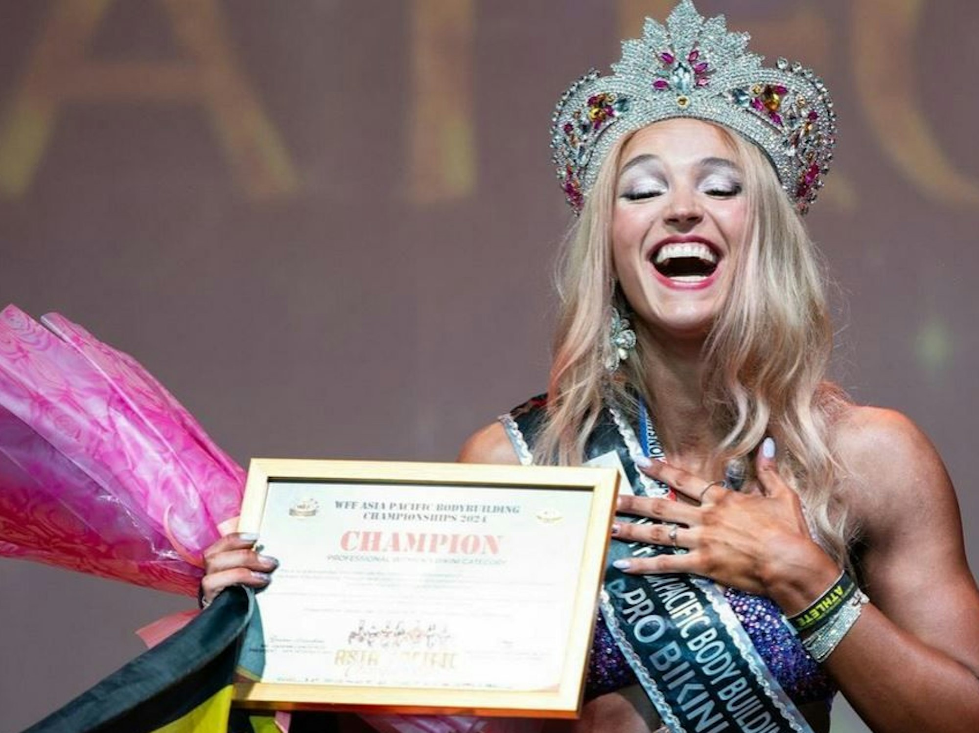 Lia Liebing steht auf der Bühne und hält ihre Urkunde in der Hand.