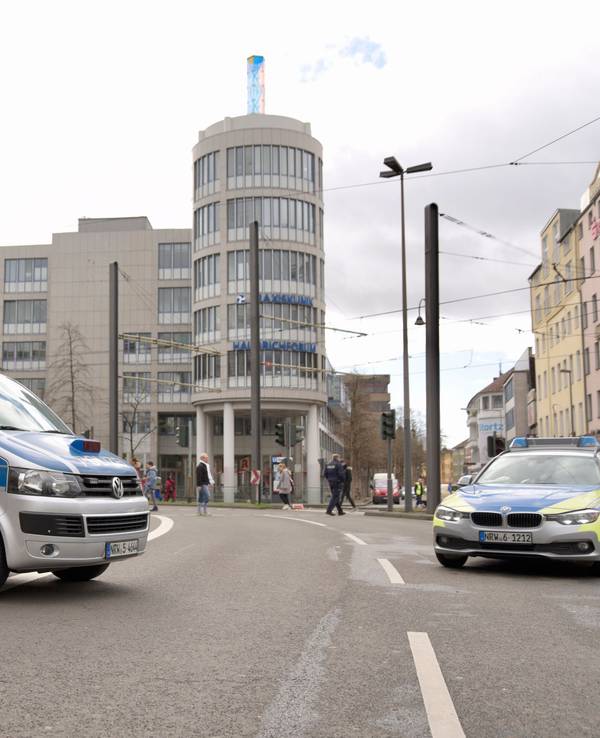 Polizei sperrt eine Straße in Köln am Rosenmontag mit zwei Streifenwagen ab.