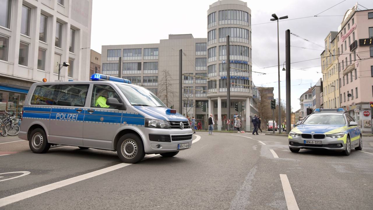 Polizei sperrt eine Straße in Köln am Rosenmontag mit zwei Streifenwagen ab.