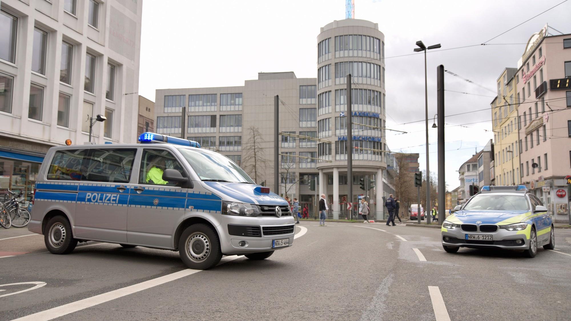 Polizei sperrt eine Straße in Köln am Rosenmontag mit zwei Streifenwagen ab.