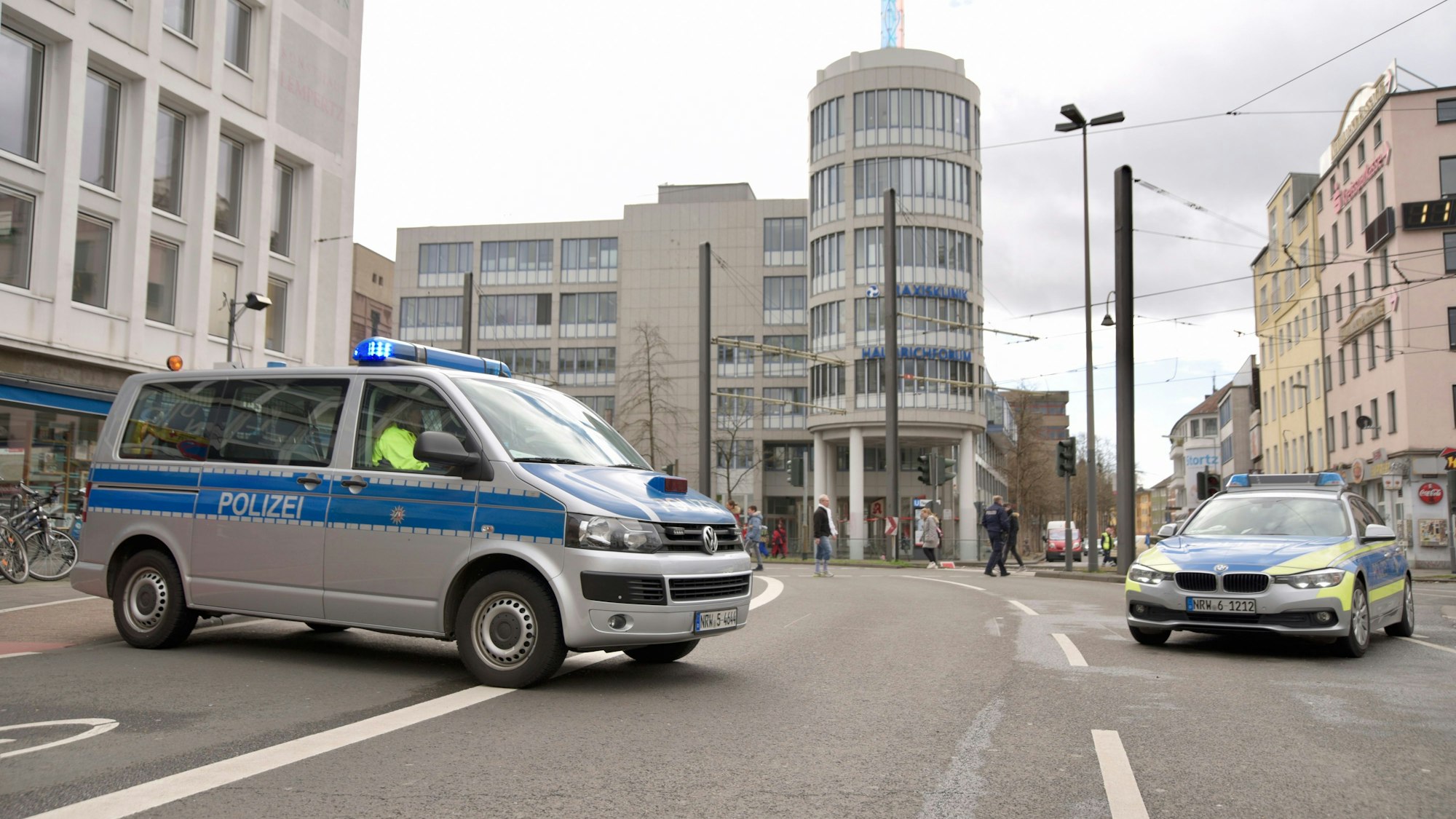 Polizei sperrt eine Straße in Köln am Rosenmontag mit zwei Streifenwagen ab.