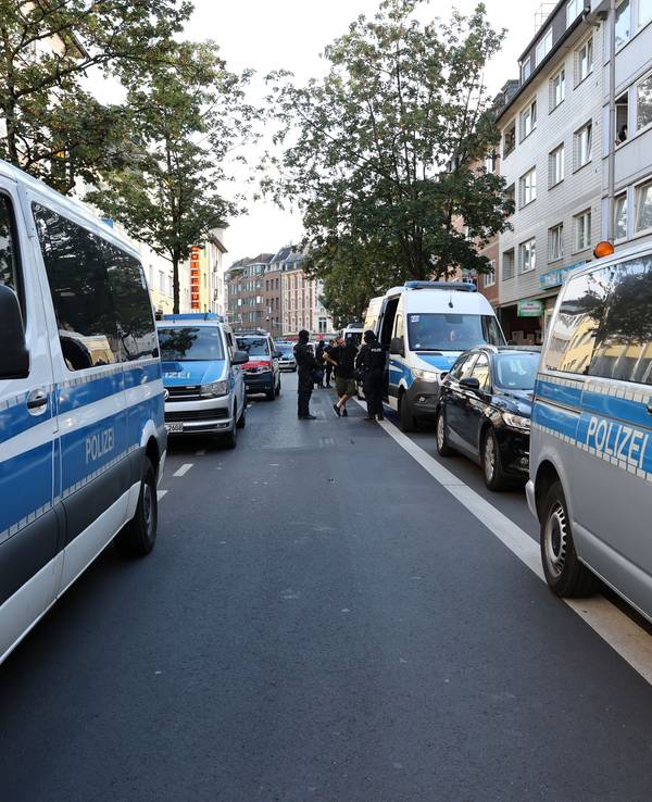 Einsatzfahrzeuge der Polizei säumen beide Seiten einer Straße.