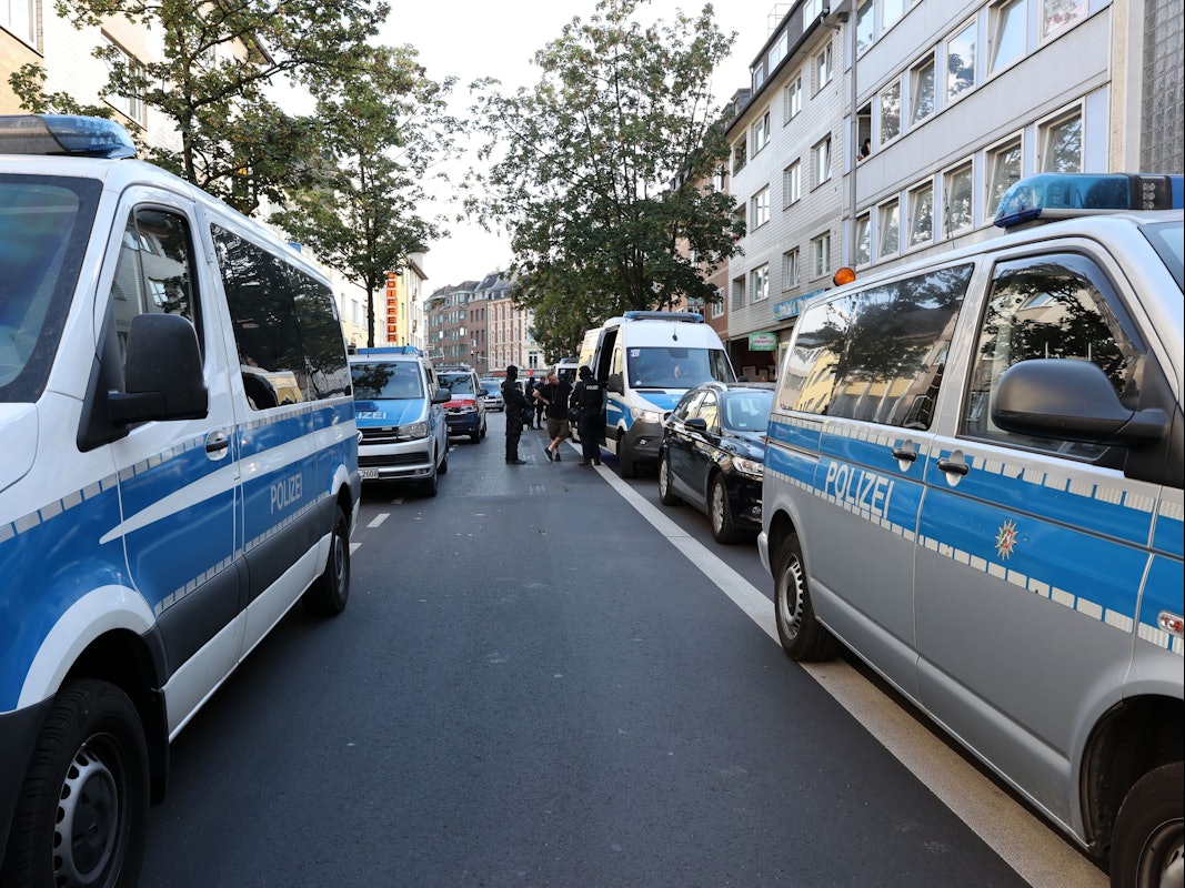 Einsatzfahrzeuge der Polizei säumen beide Seiten einer Straße.