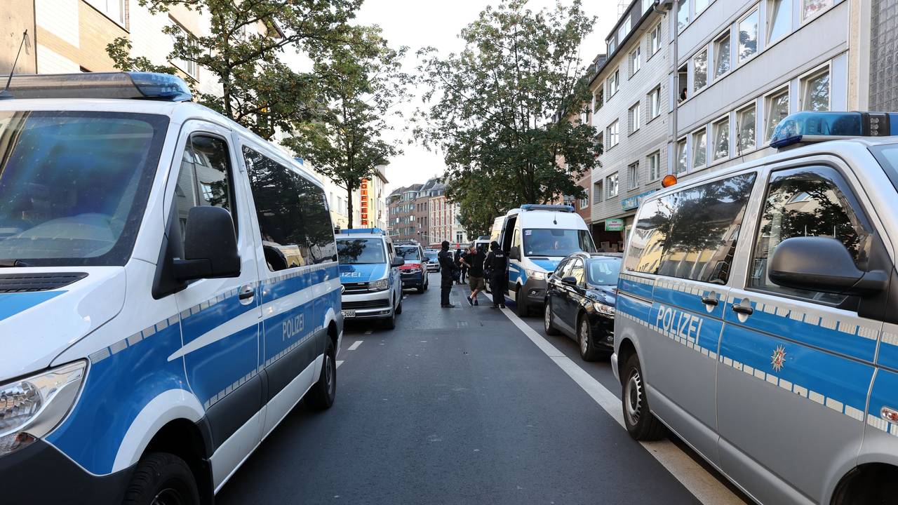 Einsatzfahrzeuge der Polizei säumen beide Seiten einer Straße.