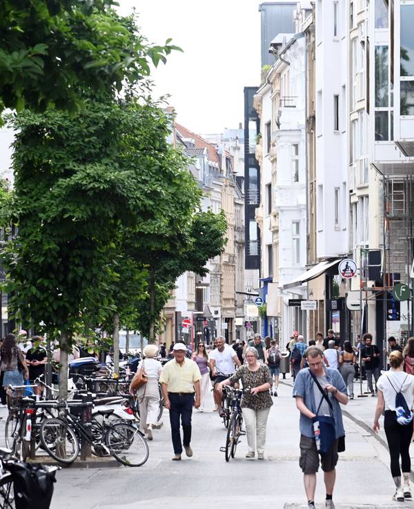 Menschen gehen über die Ehrenstraße in Köln. Es ist eine der beliebtesten Shoppingmeilen der Stadt.