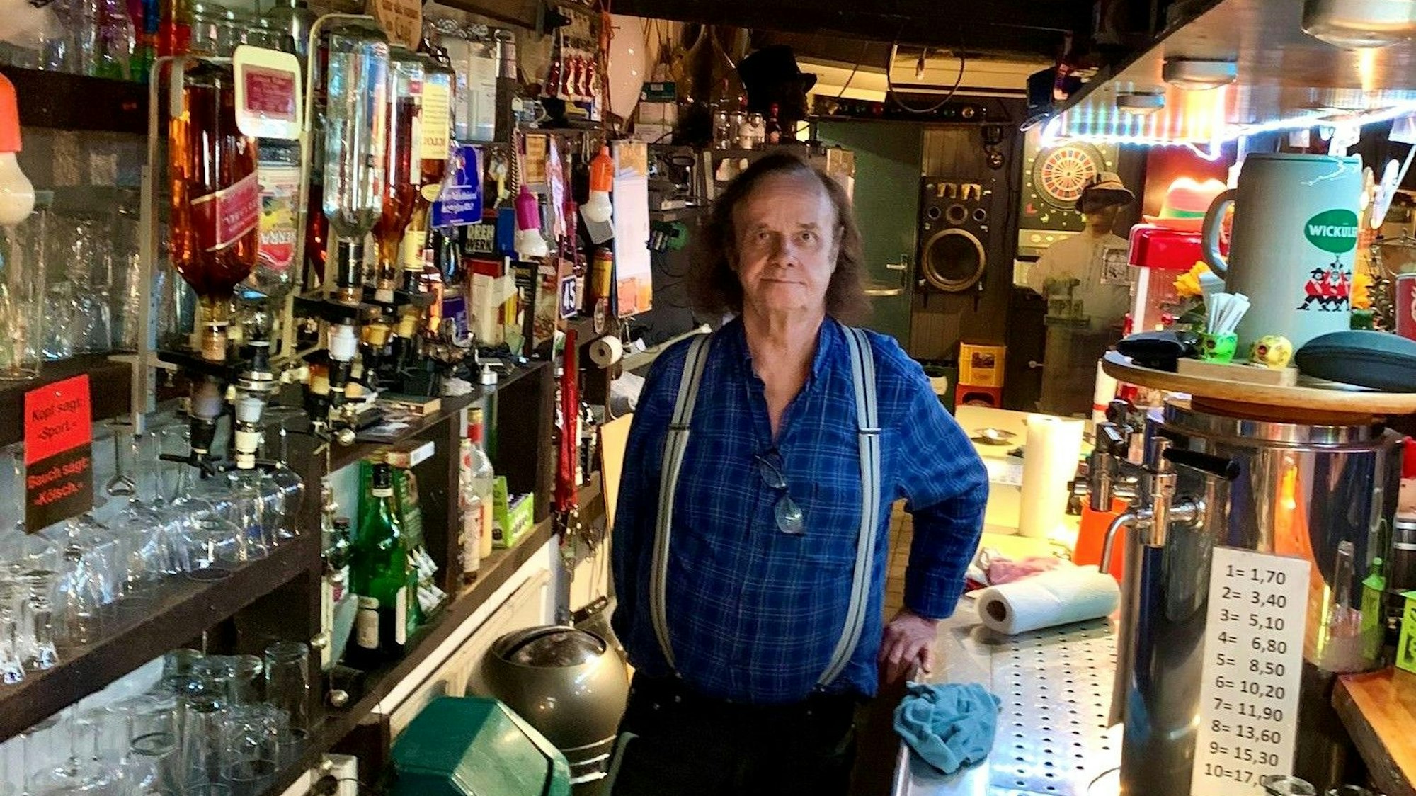 Ein Mann steht hinter einer Kneipentheke.