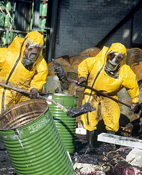 Feuerwehrleute in Schutzkleidung räumen einige Tage nach einem Brand in einem Chemiewerk des Schweizer Chemieunternehmens Sandoz die Trümmer auf.