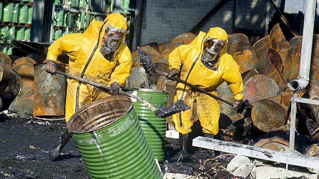Feuerwehrleute in Schutzkleidung räumen einige Tage nach einem Brand in einem Chemiewerk des Schweizer Chemieunternehmens Sandoz die Trümmer auf.