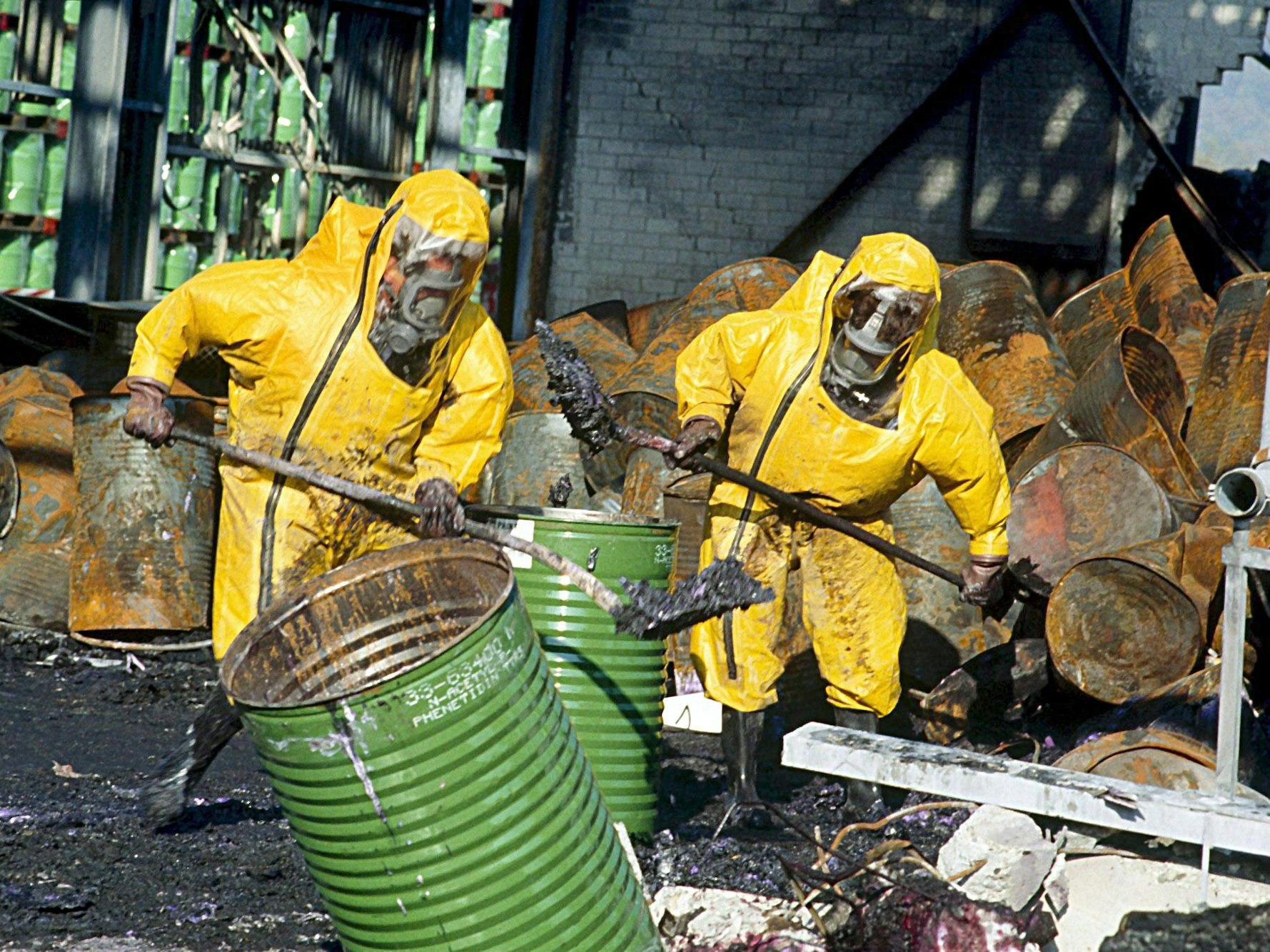 Feuerwehrleute in Schutzkleidung räumen einige Tage nach einem Brand in einem Chemiewerk des Schweizer Chemieunternehmens Sandoz die Trümmer auf.